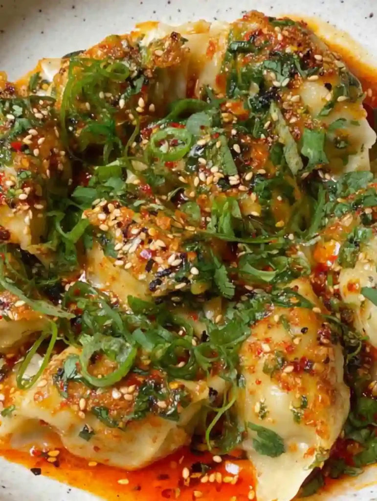 Close-up of dumpling bake in chili oil with sesame and herbs